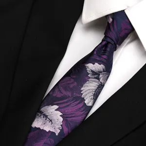 Close-up detail of a purple floral patterned silk necktie paired with crisp white shirt.