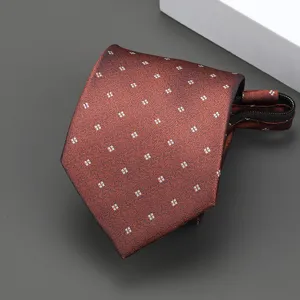 Primer plano de corbata con cremallera para hombre marrón óxido con patrón geométrico blanco.