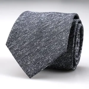 Detailed view of a stylish dark grey textured men business suit tie with subtle white speckles.