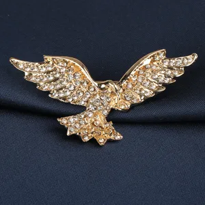 Nahaufnahme einer goldenen Adlerbrosche mit glänzenden Strasssteinen, perfekt für Anzüge.