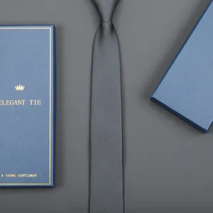 Dark grey textured necktie detail showcasing fine woven fabric and matching blue gift box.