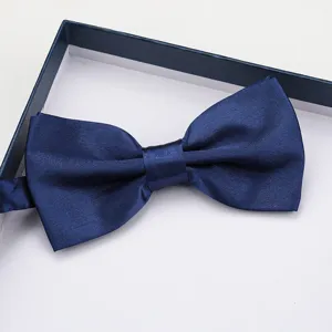 Detail shot of navy blue satin bow tie in gift box, elegant accessory for formal suits.