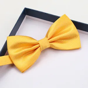 Detailed close-up of a stylish yellow grid bow tie neatly presented inside a classic gift box.