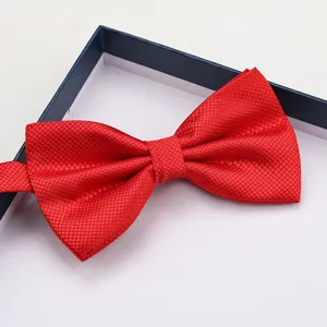 Close-up of the elegant red textured grid bow tie detail, perfect for formal wedding attire.