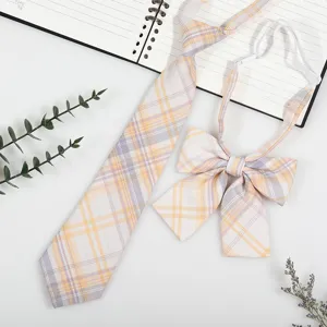 Detail shot of Japanese college style plaid necktie and bow tie set in yellow and purple tones.