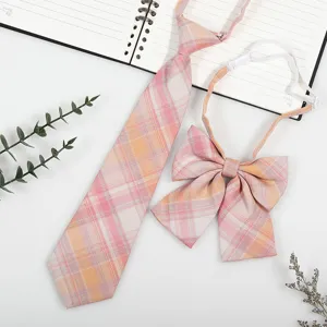 Detailed shot of Japanese JK style plaid necktie and bow tie set in pink and orange tones.