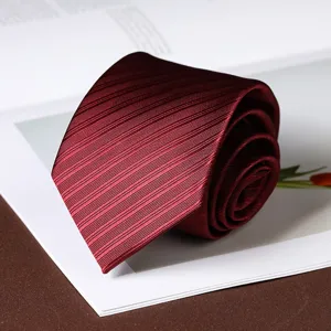 Close-up detail shot of a rolled burgundy necktie featuring fine textured diagonal stripes.