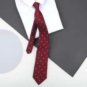 Detail view of burgundy zipper necktie with pink pattern on white shirt backdrop.