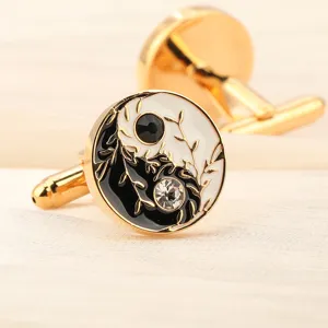 Détail de boutons de manchette dorés avec émail noir et blanc chic et de brillants cristaux.
