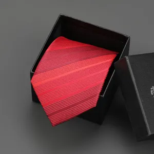 Detailed close-up view of the classic red striped necktie texture inside a black gift box.
