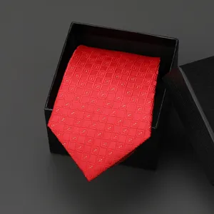Red patterned necktie detail view, premium geometric design inside elegant black gift box.