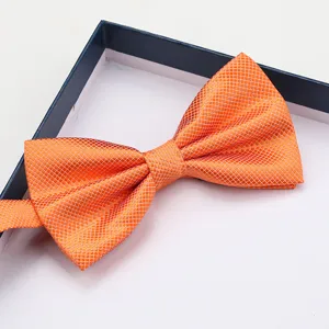 Detailed view of the orange grid bow tie inside a gift box, showing fine texture and shape.