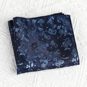 Gedetailleerd overzicht van een donkerblauwe pochet met bloemenmotief en vintage stijl voor pakken.