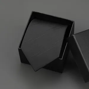 Detailed view of a black business tie with subtle diagonal stripes, elegantly packaged in a box.