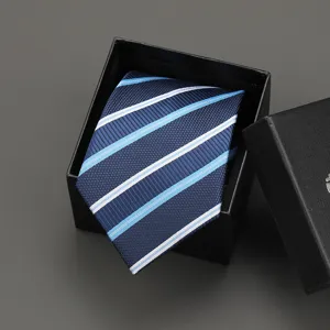 Close-up detail of a classic blue striped necktie neatly folded inside a black gift box.