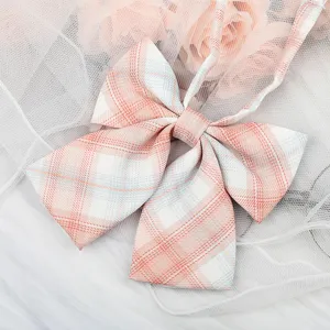 Closeup of pink white plaid JK bow tie detail, sweet Japanese school uniform collar ribbon accessory.