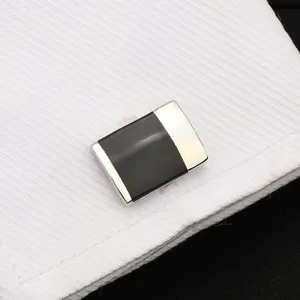 Gros plan détaillé de bouton de manchette rectangulaire en métal avec insert noir chemise