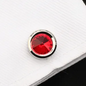 Vue de détail d'un bouton de manchette en cristal rouge étincelant sur chemise blanche.