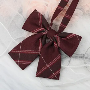 Detailed close-up of a dark red plaid JK bow tie with ribbons, perfect for school uniform shirts.