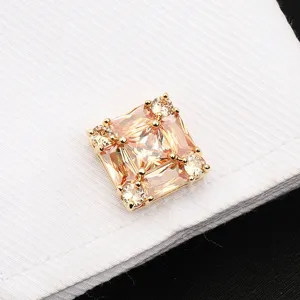 Gros plan détaillé d'un bouton de manchette carré luxueux en cristal de couleur champagne.