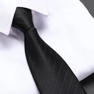 Detail shot of a classic black textured necktie paired with a crisp white dress shirt.