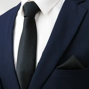 Close-up detail of black textured men's necktie and matching pocket square for business suit.