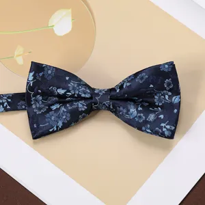 Detail shot of dark blue floral woven bow tie, elegant men's suit accessory for formal wear.