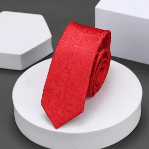 Detalle de corbata estrecha roja que muestra un fino patrón floral jacquard y gran textura.