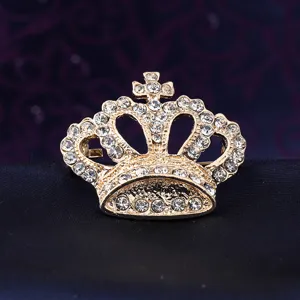 Close-up detail of a vintage gold crown brooch with sparkling rhinestones for men suits.