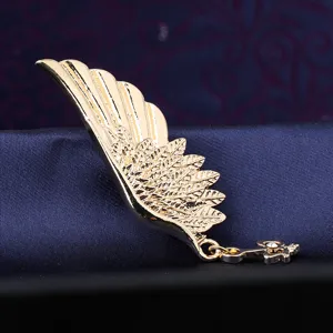 Vintage gold wing brooch close-up view showing delicate feather texture and hanging key pendant.