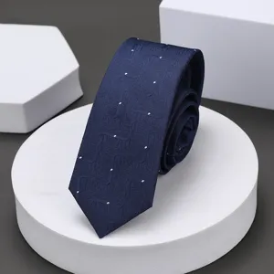 Primer plano de corbata estrecha azul oscuro con textura geométrica sutil y puntos blancos.