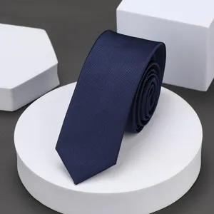 Detalle de corbata estrecha azul marino, tejido texturizado premium para ropa de trabajo.