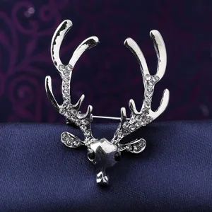 Close-up of a vintage silver deer head brooch, detailed with sparkling rhinestones on antlers.
