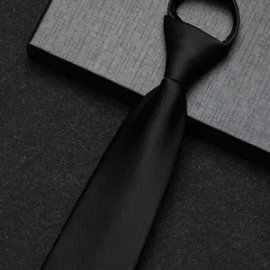 Gedetailleerd overzicht van de zwarte ritsdas met gladde textuur en nette voorgeknoopte knoop.