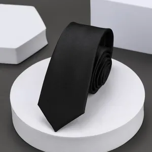 Detalle en primer plano de una corbata negra estrecha clásica enrollada en un soporte.