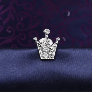 Close-up of silver crown brooch with sparkling rhinestones, detailed craftsmanship pin badge.