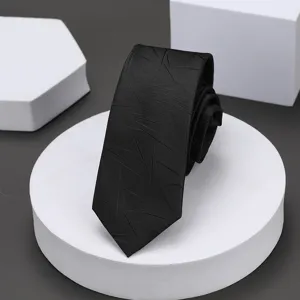 Primer plano de corbata estrecha negra con sutil patrón geométrico detalle elegante.