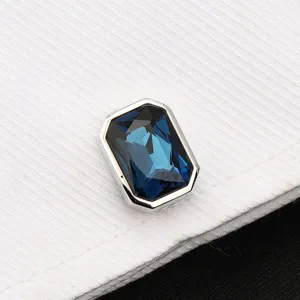Gros plan détaillé d'un bouton de manchette élégant en cristal bleu avec monture argentée.