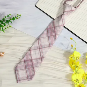 JK style plaid short necktie detail shot, pre-tied lazy design with soft pink check pattern.