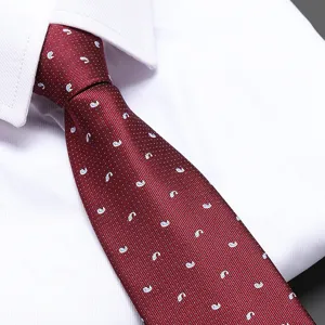 Close-up detail of a classic red patterned business necktie featuring subtle white dots on fabric.