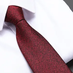 Detailed view of a red textured men dress tie with black speckles on a white shirt.