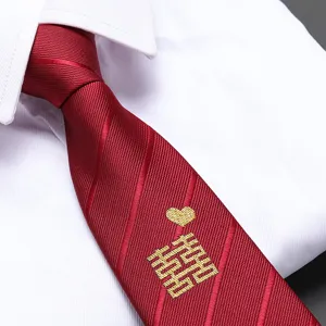 Close-up detail of red wedding tie with traditional golden double happiness embroidery.