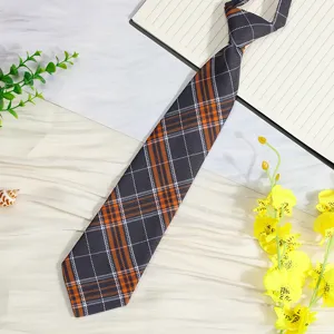 Detail view of a pre-tied JK plaid necktie, stylish short grey and orange plaid tie for uniform.