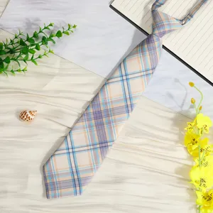 Detail shot of a pre-tied plaid JK uniform necktie with blue and beige grid pattern.