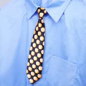 Primo piano della cravatta nera con simpatiche stampe di mele gialle abbinata a una camicia.