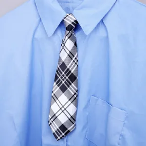 Vista dettagliata di cravatta a quadri bianchi e neri con camicia blu in stile retrò studentesco.