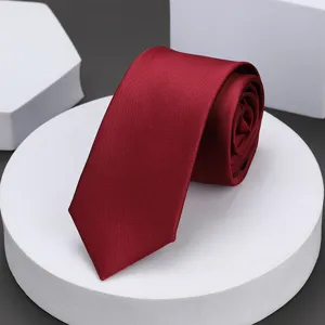 Vista detallada de corbata estrecha burdeos, elegante diseño liso para ropa formal de negocios.