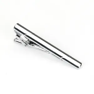 Vue detaillee pince a cravate metal argente, surface poli brillante, accessoire homme.
