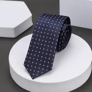 Vista detallada de una corbata azul marino con pequeños motivos cuadrados rosados.