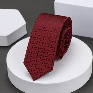 Vista detallada de una corbata delgada roja con patrón geométrico para vestimenta formal.